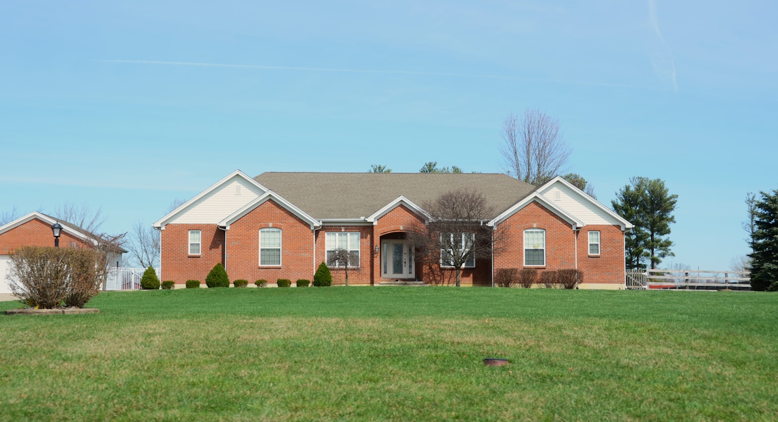 Two-story brick Houston-area home with a manicured front lawn and clean bed lines.